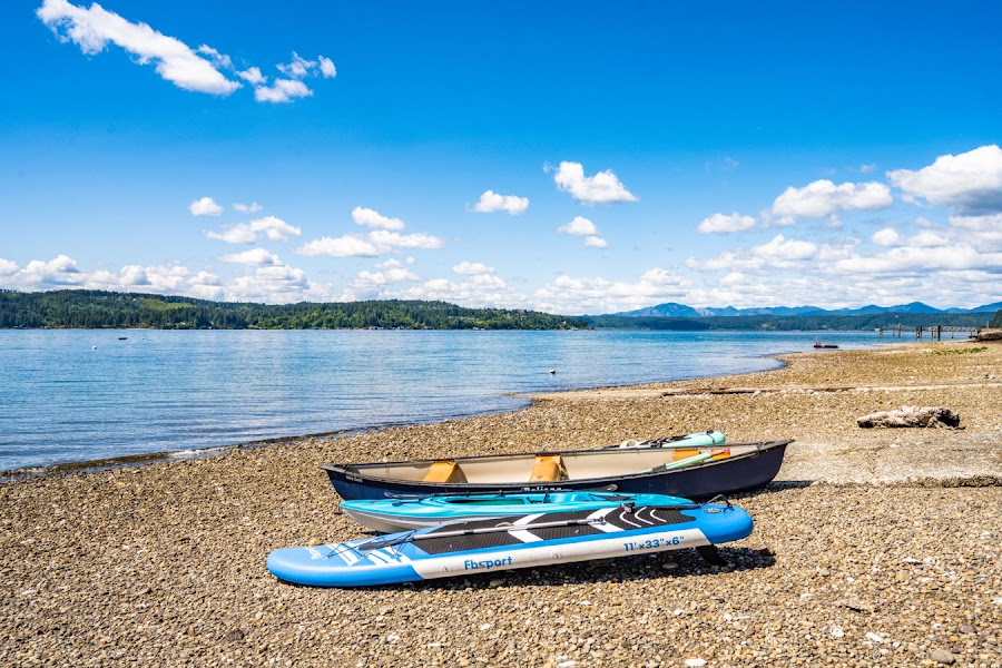 Kayaks and paddleboards on a Hood Canal pebble beach